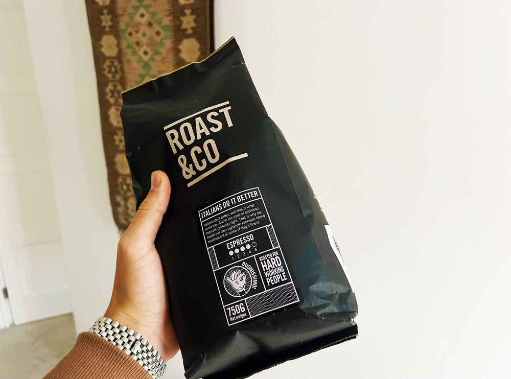 Zak van 750g Roast & Co espresso koffiebonen, met de Italiaanse vlag en de boodschap 'Italians do it better'. Perfect voor krachtige espresso’s, zorgvuldig gebrand voor de harde werkers die het beste verdienen. Verkrijgbaar bij CaféHuis.